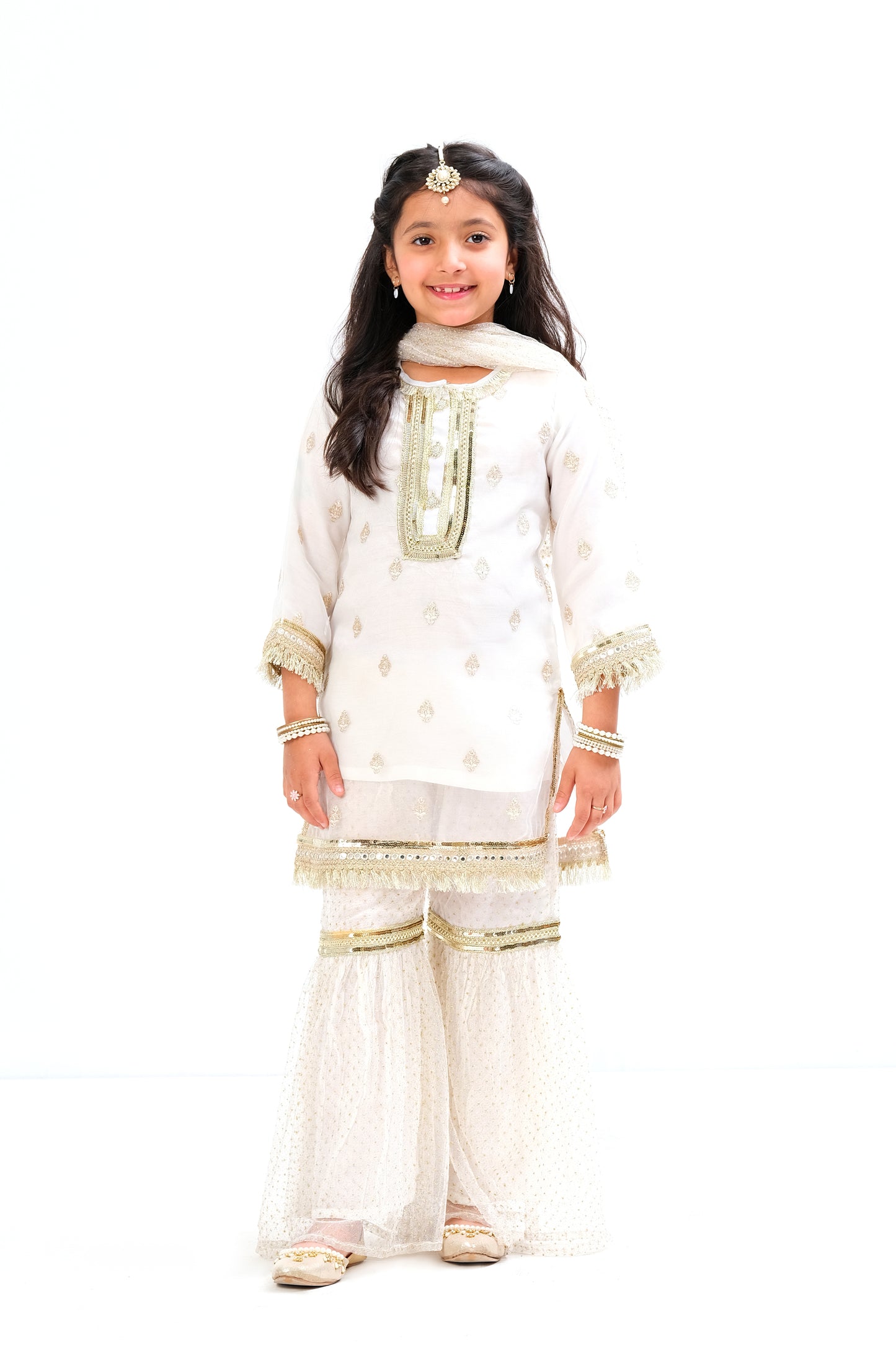 White organza shirt with intricate embroidery motive all over the shirt and golden laces on neck and sleeves. Glitter net gharara and dupatta.