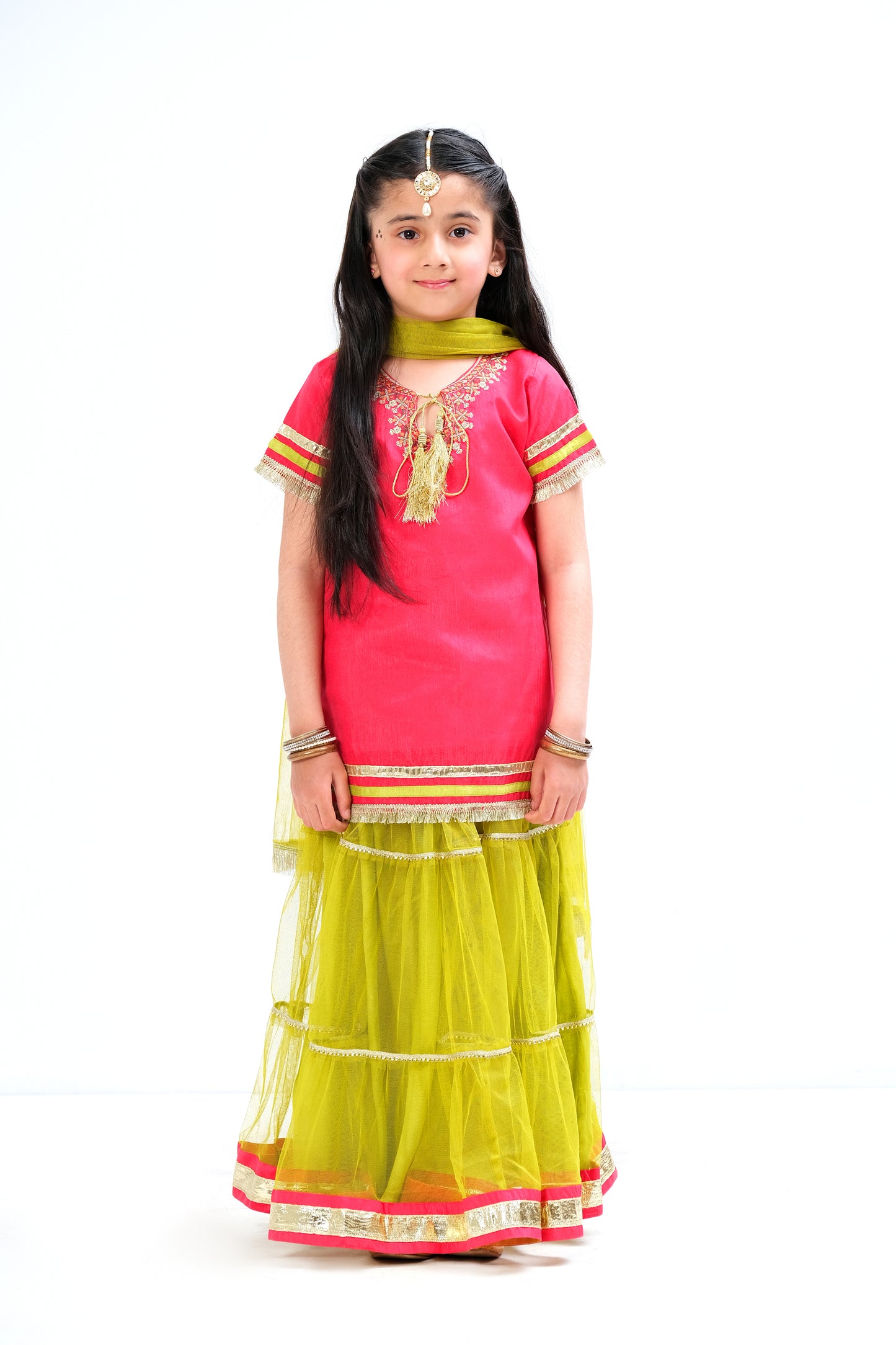 Raspberry color ethnic shirt with embroidery and laces. Bight green paneled lehnga with chatta patti border and golden lace on panels.