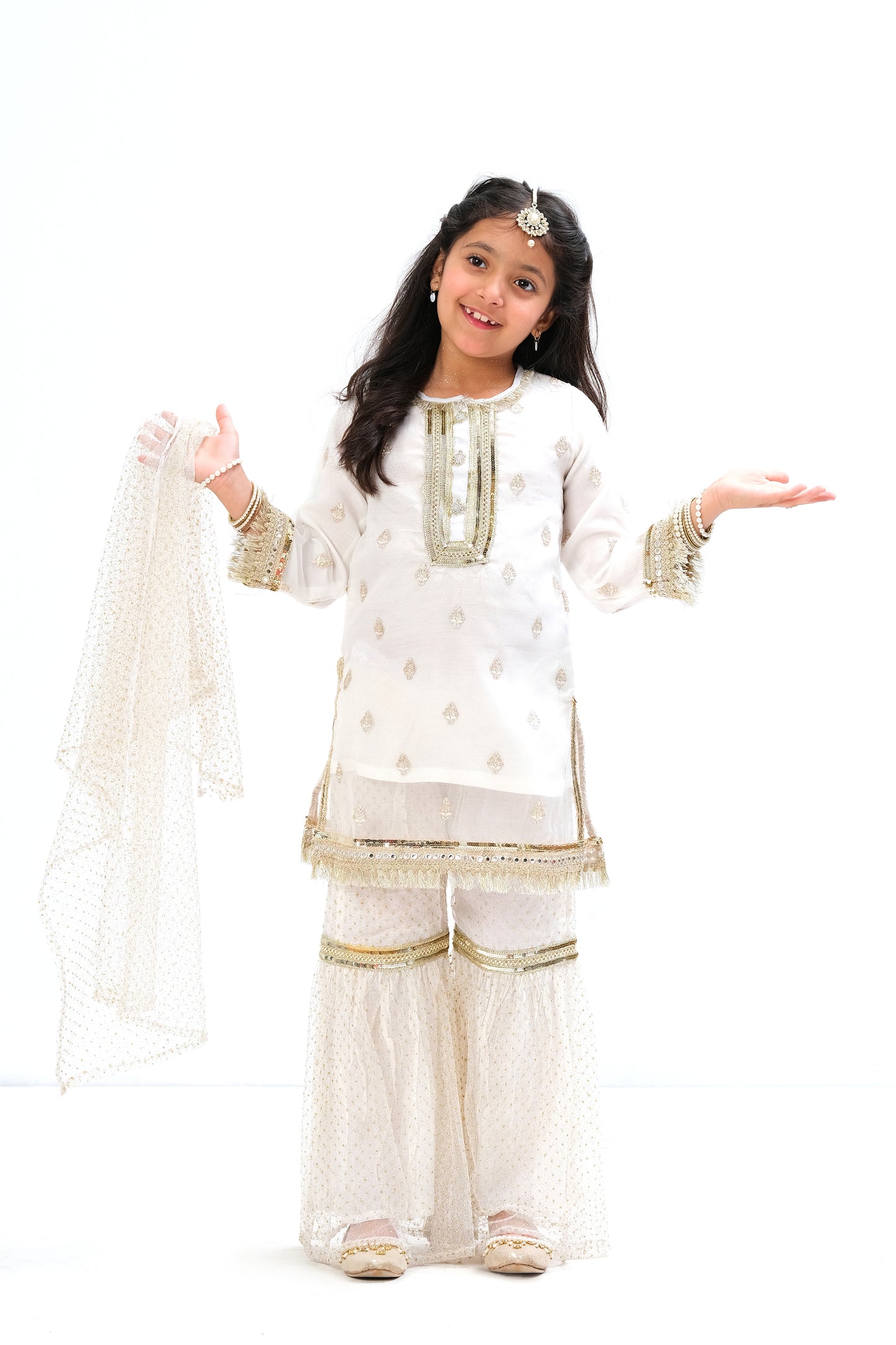 White organza shirt with intricate embroidery motive all over the shirt and golden laces on neck and sleeves. Glitter net gharara and dupatta