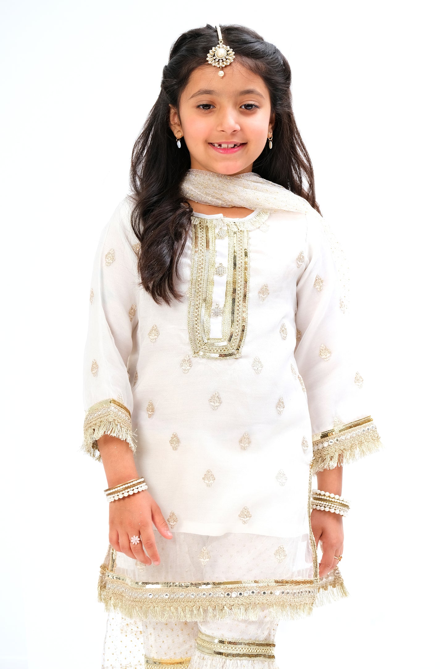 White organza shirt with intricate embroidery motive all over the shirt and golden laces on neck and sleeves. Glitter net gharara and dupatta