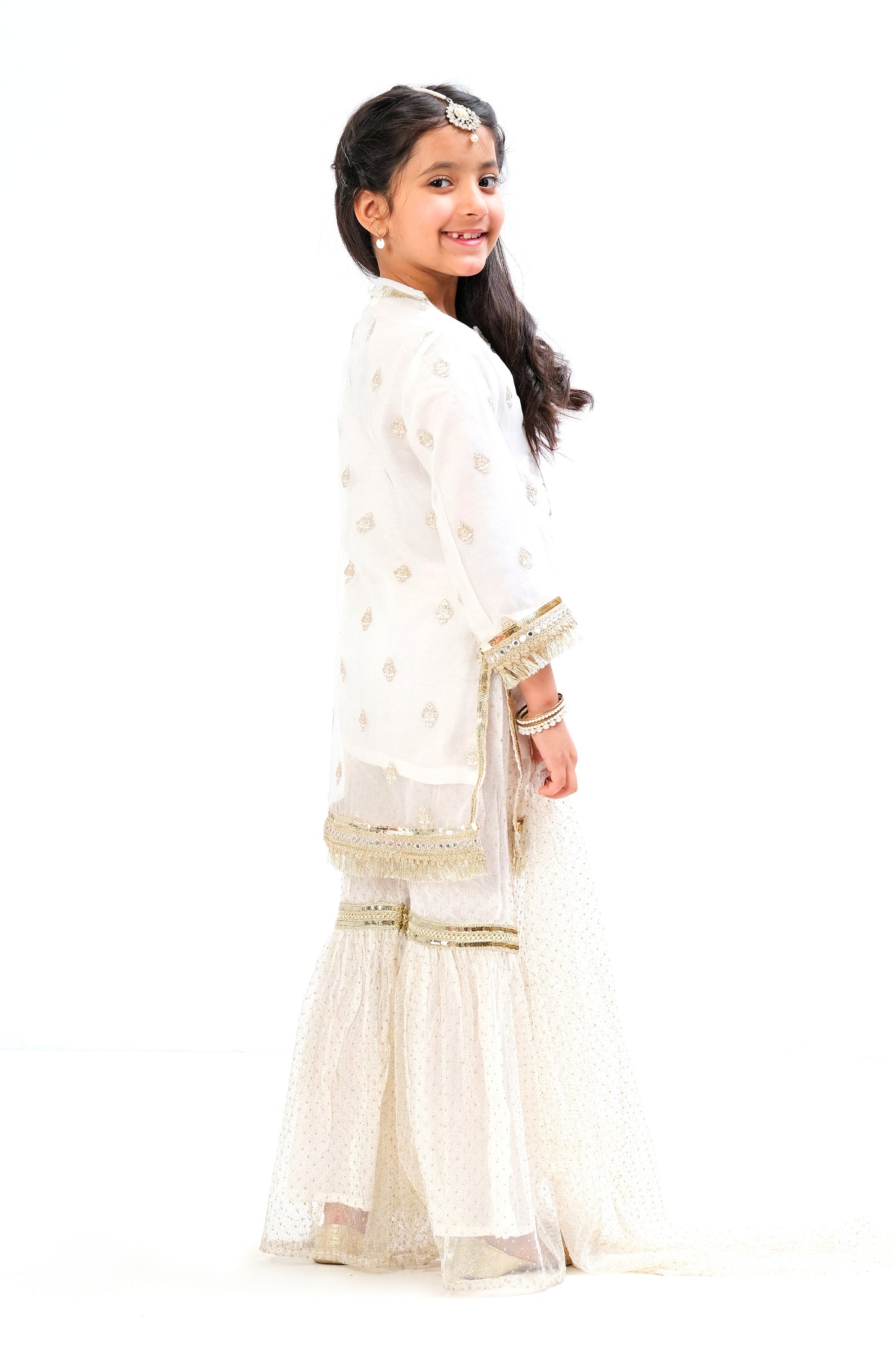 White organza shirt with intricate embroidery motive all over the shirt and golden laces on neck and sleeves. Glitter net gharara and dupatta